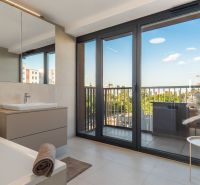 Bathroom with a view and balcony, apartment construction, floor with wood decor.