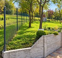 The garden of a family house in Košariská in Oščadnica, with a fence and greenery on a slope.