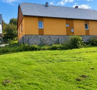 A family house in Oščadnica on Košariská Street with a yellow facade and a grass-covered plot.