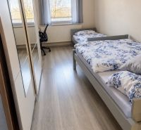 A room with two beds and a wooden decor floor in a family house.