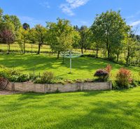 A garden at a family house in Košariská in Oščadnica with a lawn, trees, and shrubs.