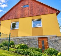 The family house on Košariská Street in Oščadnica has a yellow facade and a stone foundation.