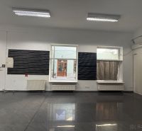 Commercial space with a gray floor and a large window.