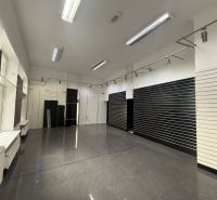 Commercial premises with dark walls and gray tiles, available for rent.