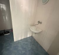 Commercial premises with a sink and blue tiles on the floor.