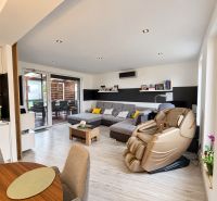Living room with a massage chair and wooden decor flooring in a family house.
