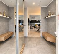 A hallway with shelves and a bench, a floor with a wooden decor in a family house.