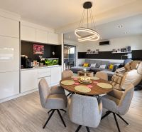 Living room in a family house with wood-patterned flooring and comfortable seating.