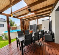 The terrace of a family house in Mosonmagyaróvár with seating and a pool in the garden.
