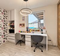A workspace in a family house with a wooden decor floor, decorative wallpaper.