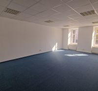 A bright spacious office with a blue carpet and white walls.