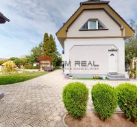 A family house on Hlavná Street in Miloslavov with a landscaped garden and a paved driveway.