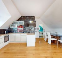 A kitchen with a dining area in a two-room apartment with a wooden decor floor.