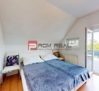 Bright bedroom with a bed and a chair, 2-room apartment with wooden floor decor.