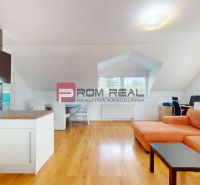 Living room with an orange sofa, a desk, and a wooden decor floor in a two-room apartment.