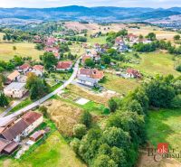 Aerial view of residential plots in the town of Detva with surrounding nature and buildings.