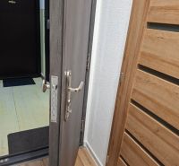 Entrance door with metal fittings in a 1-room apartment, floor with wooden decor.