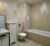 Bathroom in a 2-room apartment with a bathtub, sink, cabinet, and toilet.