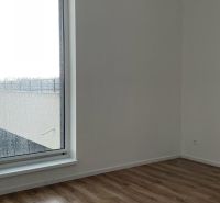 A room in a 2-room apartment with a large window and a floor with a wooden decor.