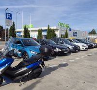 Parking lot with cars and a motorcycle near the shopping center in Malacky on Javorova Street.