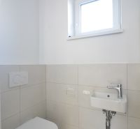 A toilet with a sink in a 3-room apartment, simple white and gray color scheme.