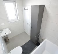 Bathroom in a 3-room apartment with a bathtub, sink, and cabinet.