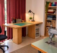 Sewing workshop in a family house with a work table and a sewing machine.