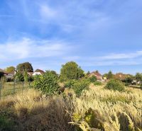 Plots for residential development in Jasová with views of houses and awakening nature.