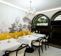 Luxury commercial spaces with a colorful sofa, decorative wallpaper, and elegant serving.
