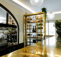 Elegant wine shop and bar in commercial premises with modern lighting and gold details.