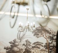 A stylish chandelier illuminates a table decorated with golden hues in commercial premises.