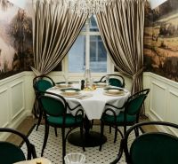 Dining table with luxurious table setting and chandelier in commercial premises.
