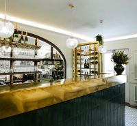 Interior of commercial premises with a shiny bar, hanging glasses, and decorative lighting.