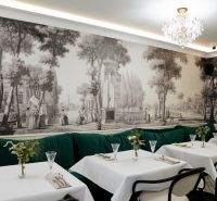 A restaurant with historical wallpaper, a crystal chandelier, and green seating in commercial premises.