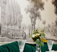 A flower vase on a table in commercial premises with a large mural.