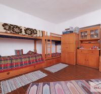 Interior of a family house with a bunk bed, dressers, and a floor with a wooden decor.