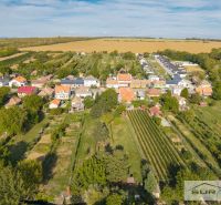 An aerial view of family houses on Hlavná Street in Štefanová surrounded by gardens and nature.