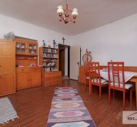 Dining room in a family house with wooden furniture, books, and a floor with a wood decor.