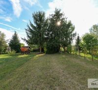 The garden of the family house on Hlavná Street in Štefanová, with large coniferous trees and a gazebo.