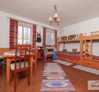 In the family house, there is a bunk bed, a table, and a floor with a wooden decor.