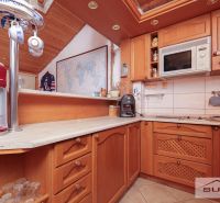 A kitchen in a family house with wooden decor, a map, and kitchen equipment.