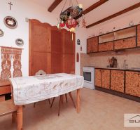 A kitchen in a family house with rustic decor and wall decorations above the table.