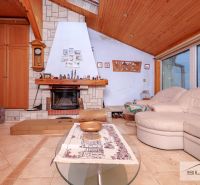 Living room with a fireplace and a sofa in a family house, floor with wooden decor.