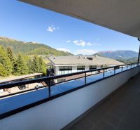 The balcony of the 3-room apartment in Donovaly offers a view of the mountains and rooftops.