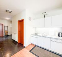 A kitchen in a 3-room apartment with white cabinets and a wood-patterned floor.