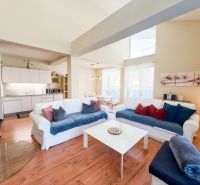 Living room in a 3-room apartment with a wooden decor floor and a light-colored sofa.