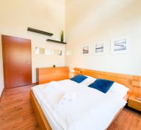 A bedroom with wood-patterned flooring, a bed, a dresser, and decorations in a 3-room apartment.