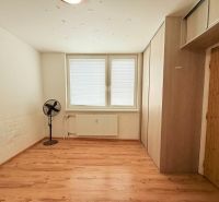 A room with a wooden floor decor, a fan, and storage space in a 3-room apartment.
