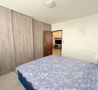Bedroom with a bed, built-in wardrobe, and passage to the living room in a 3-room apartment.