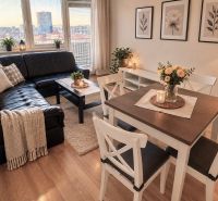 Living room in a 2-room apartment with a leather sofa and a wooden decor floor.